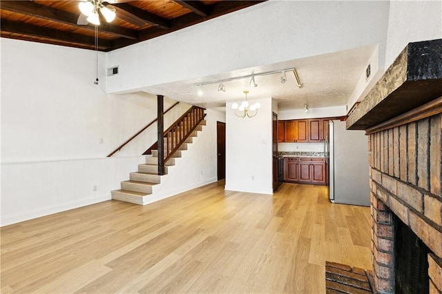 2305 Cleary Ave Unit 214, Metairie, LA 70001 - unfurnished living room featuring a wooden ceiling with exposed beams, stairs, a brick fireplace, light wood-type flooring, and ceiling fan