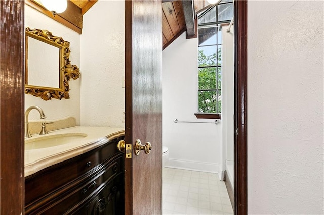 2305 Cleary Ave Unit 214, Metairie, LA 70001 - bathroom with tile patterned floors, vanity, a textured wall, and vaulted ceiling