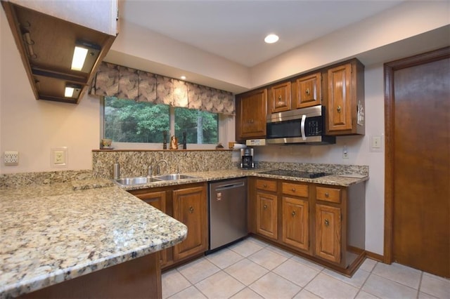 1005 Oakland Dr, Pearl River, LA 70452 - kitchen featuring appliances with stainless steel finishes, brown cabinetry, light tile patterned floors, light stone countertops, and recessed lighting