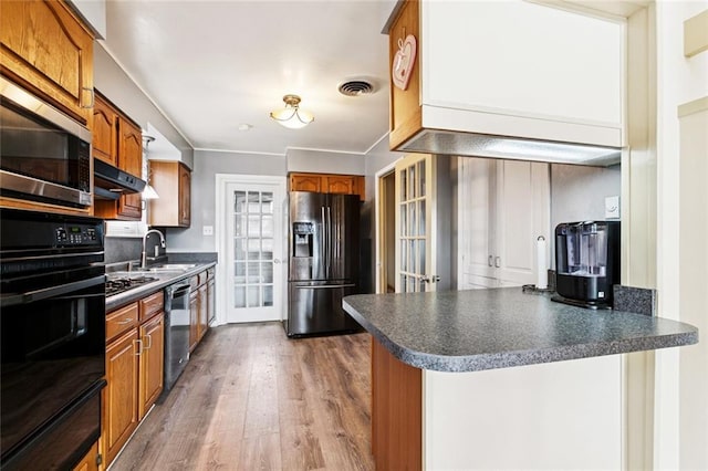 822 Homestead Ave, Metairie, LA 70005 - kitchen featuring stainless steel appliances, dark countertops, a peninsula, and brown cabinets