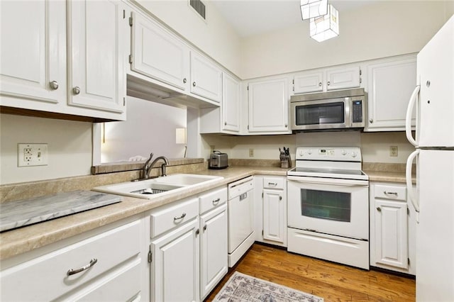 800 Rue Burgundy St Unit 223, Metairie, LA 70005 - kitchen featuring white appliances, white cabinets, light countertops, and wood finished floors