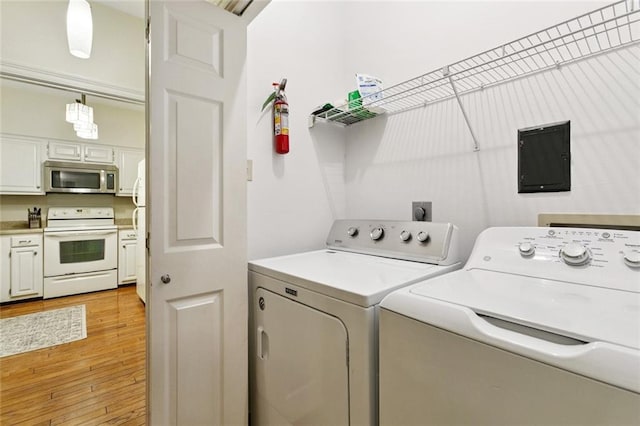 800 Rue Burgundy St Unit 223, Metairie, LA 70005 - laundry room featuring washing machine and clothes dryer, light wood finished floors, and electric panel