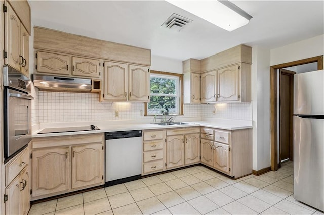 6213 Rosalie Ct, Metairie, LA 70003 - kitchen with stainless steel appliances, under cabinet range hood, light countertops, backsplash, and light brown cabinetry
