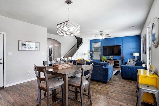 801 Lakeshore Village Dr, Slidell, LA 70461 - dining room featuring arched walkways, ceiling fan, dark wood-style floors, a chandelier, and stairway