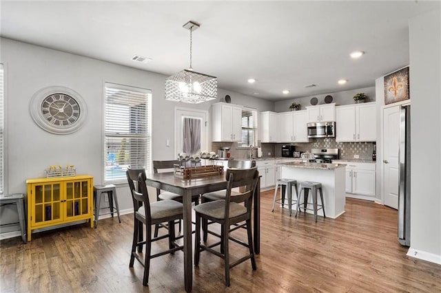 801 Lakeshore Village Dr, Slidell, LA 70461 - dining area with a chandelier, wood finished floors, and recessed lighting