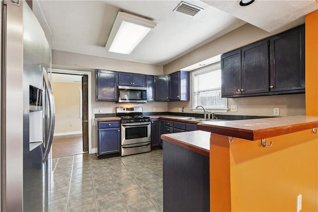 501 Oriole St, Metairie, LA 70006 - kitchen with appliances with stainless steel finishes, a peninsula, and a kitchen bar