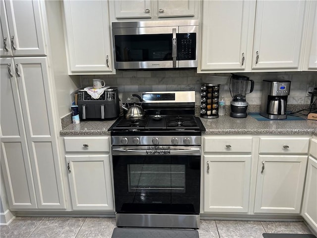 532 Deerfield Rd, Terrytown, LA 70056 - kitchen with stainless steel appliances, light tile patterned floors, and white cabinetry