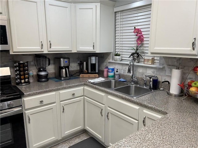 532 Deerfield Rd, Terrytown, LA 70056 - kitchen with stainless steel range with gas cooktop, white cabinetry, tasteful backsplash, and tile patterned floors