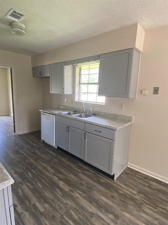 1411 Patriot St, Slidell, LA 70458 - kitchen featuring white dishwasher, a textured ceiling, dark wood-type flooring, and gray cabinets