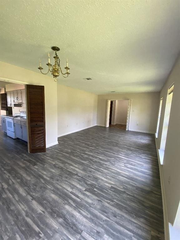 1411 Patriot St, Slidell, LA 70458 - unfurnished living room featuring dark wood-style floors, a chandelier, and a textured ceiling