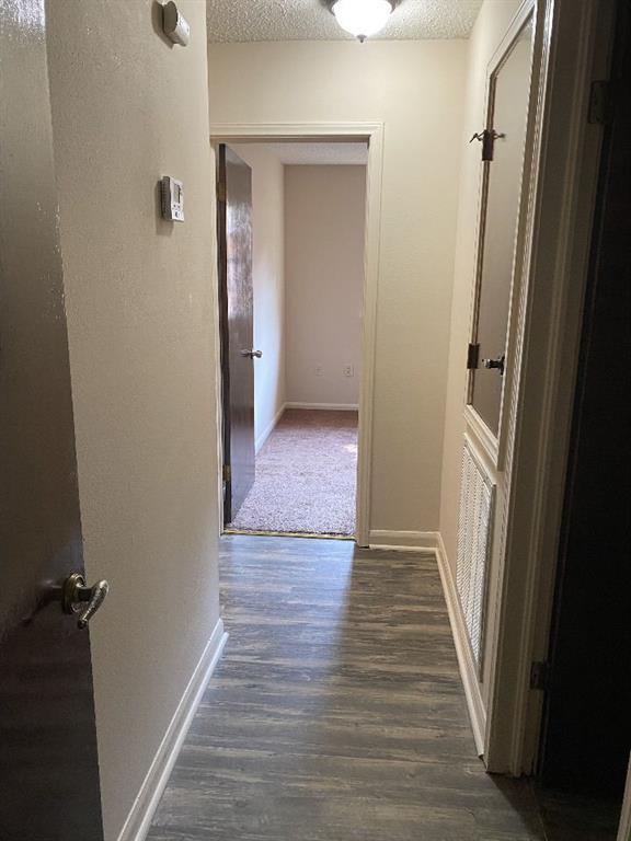 1411 Patriot St, Slidell, LA 70458 - hallway with dark wood-style floors and a textured ceiling