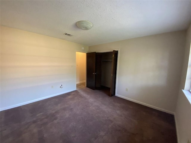 1411 Patriot St, Slidell, LA 70458 - unfurnished bedroom featuring a closet, dark carpet, and a textured ceiling