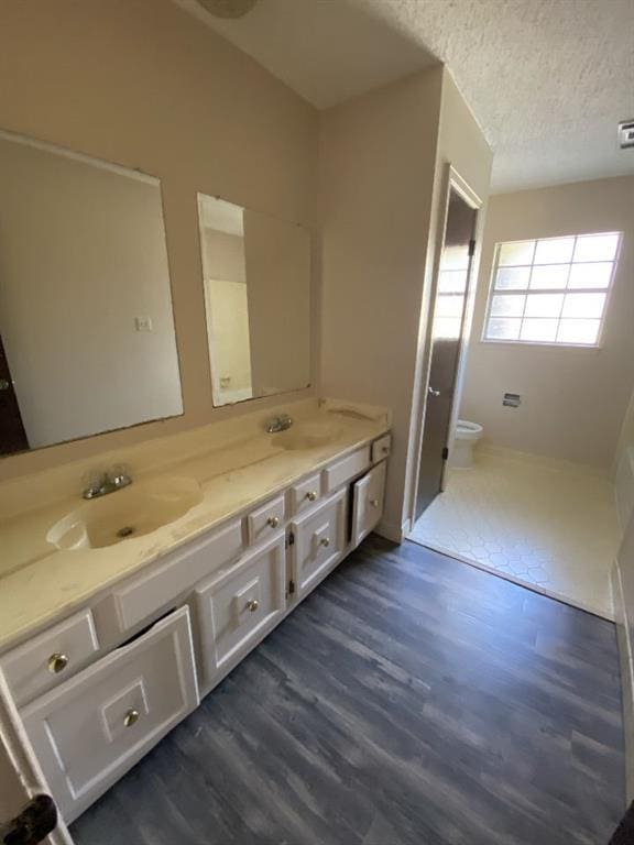 1411 Patriot St, Slidell, LA 70458 - full bath with double vanity, wood finished floors, and a textured ceiling