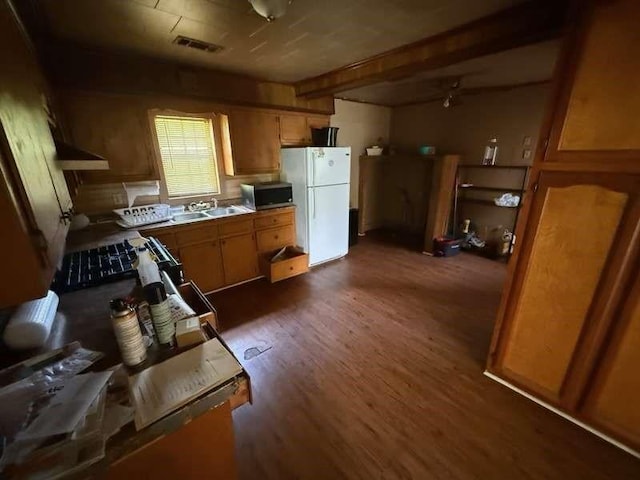 5013 Douglas Ave, Baton Rouge, LA 70805 - kitchen featuring freestanding refrigerator, stainless steel microwave, dark wood-type flooring, beam ceiling, and brown cabinets