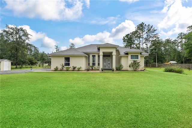22484 Treadaway St, Mandeville, LA 70471 - prairie-style home with a front lawn, stucco siding, a storage shed, gravel driveway, and roof with shingles