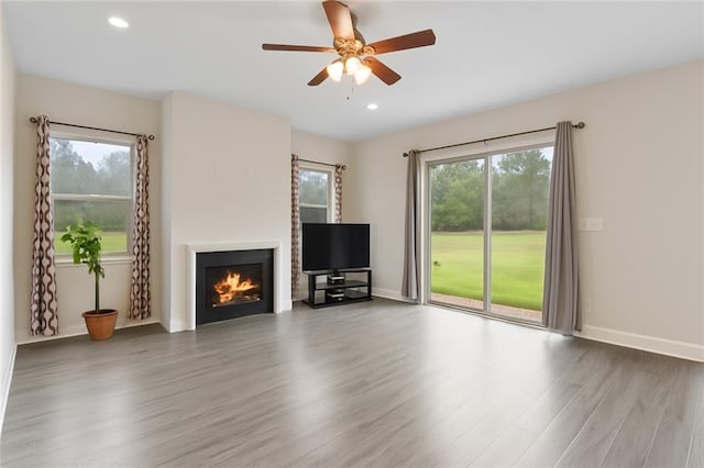 22484 Treadaway St, Mandeville, LA 70471 - unfurnished living room with a lit fireplace, wood finished floors, a ceiling fan, plenty of natural light, and recessed lighting