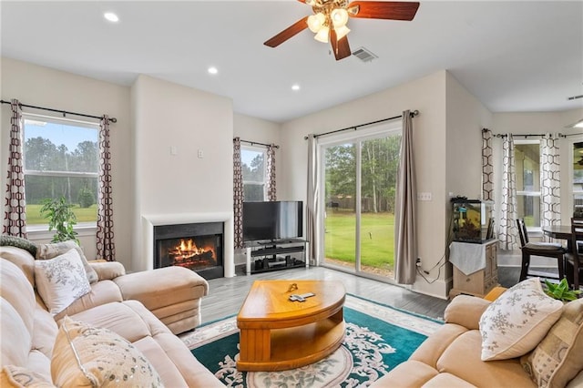 22484 Treadaway St, Mandeville, LA 70471 - living room featuring ceiling fan, wood finished floors, recessed lighting, and a lit fireplace