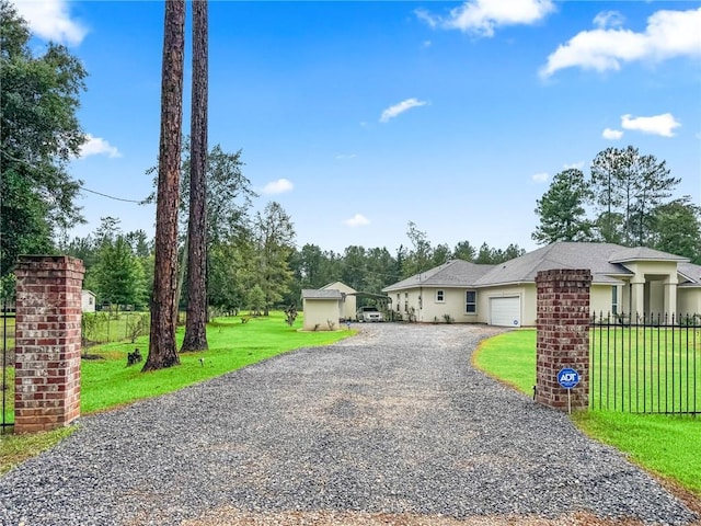 22484 Treadaway St, Mandeville, LA 70471 - ranch-style home with gravel driveway, an attached garage, and stucco siding