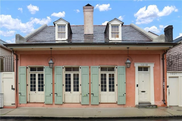 101921 Saint Peter St, New Orleans, LA 70116 - property entrance featuring a high end roof, a chimney, and stucco siding