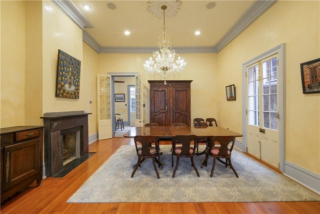 101921 Saint Peter St, New Orleans, LA 70116 - dining space featuring crown molding, wood finished floors, a chandelier, and a fireplace with flush hearth