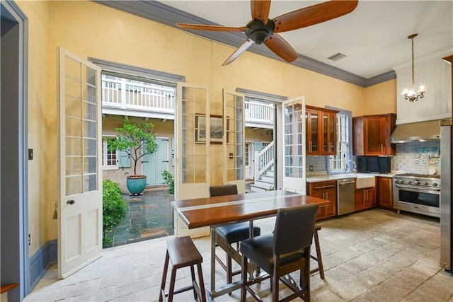 101921 Saint Peter St, New Orleans, LA 70116 - kitchen with stainless steel appliances, ornamental molding, a chandelier, a ceiling fan, and french doors