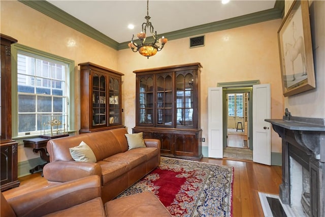 101921 Saint Peter St, New Orleans, LA 70116 - living room featuring a chandelier, crown molding, wood-type flooring, a fireplace with flush hearth, and recessed lighting