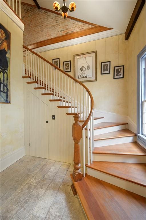 101921 Saint Peter St, New Orleans, LA 70116 - stairs featuring stone finish flooring, high vaulted ceiling, and a chandelier