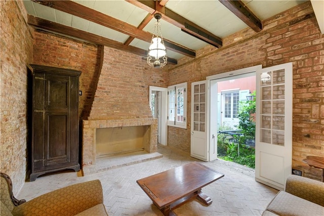 101921 Saint Peter St, New Orleans, LA 70116 - unfurnished living room with brick floors, brick wall, beam ceiling, a chandelier, and a fireplace