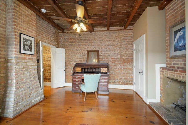 101921 Saint Peter St, New Orleans, LA 70116 - office space with a wood ceiling with exposed beams, a ceiling fan, hardwood / wood-style floors, brick wall, and a brick fireplace