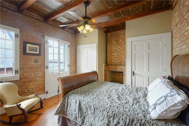 101921 Saint Peter St, New Orleans, LA 70116 - bedroom featuring brick wall, wood finished floors, a wooden ceiling with exposed beams, a fireplace, and ceiling fan
