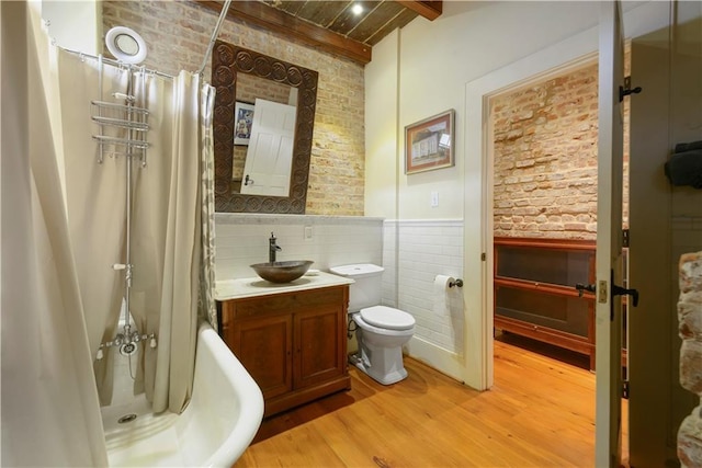 101921 Saint Peter St, New Orleans, LA 70116 - full bath featuring brick wall, a wainscoted wall, wood finished floors, vanity, and a wood ceiling with exposed beams