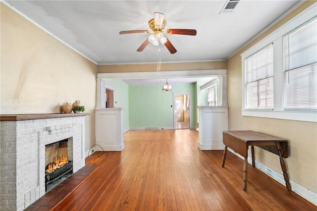 1316 Lowerline St, New Orleans, LA 70118 - living area with crown molding, wood-type flooring, a fireplace, and a ceiling fan