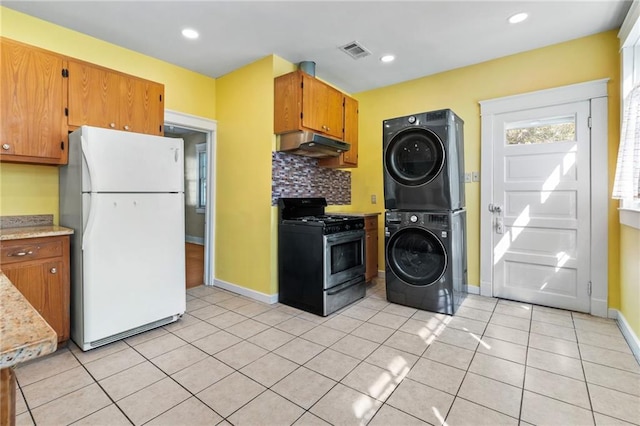 1316 Lowerline St, New Orleans, LA 70118 - kitchen with freestanding refrigerator, stainless steel gas range, stacked washer / drying machine, under cabinet range hood, and tasteful backsplash