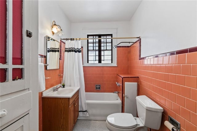1316 Lowerline St, New Orleans, LA 70118 - full bath featuring vanity, tile walls, shower / bath combo with shower curtain, tile patterned floors, and a wainscoted wall