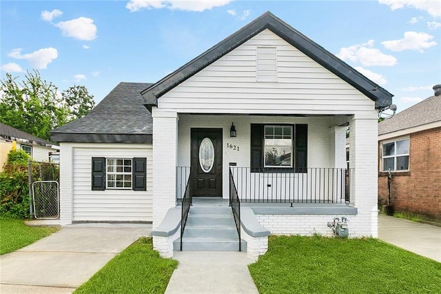 1621 Congress St, New Orleans, LA 70117 - view of front of property with a porch, a front yard, and brick siding