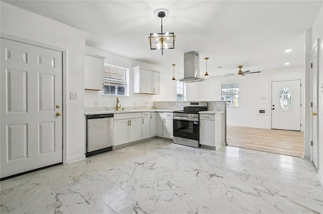1621 Congress St, New Orleans, LA 70117 - kitchen with stainless steel appliances, exhaust hood, a peninsula, light countertops, and hanging light fixtures
