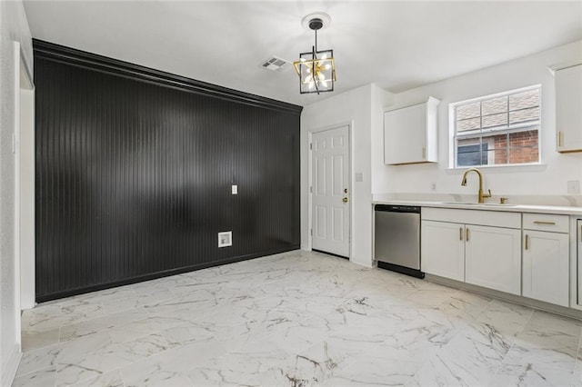 1621 Congress St, New Orleans, LA 70117 - kitchen with stainless steel dishwasher, light marble finish floors, a chandelier, light countertops, and decorative light fixtures