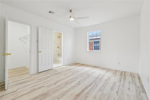 1621 Congress St, New Orleans, LA 70117 - unfurnished bedroom with wood finished floors, a spacious closet, ensuite bathroom, and a ceiling fan