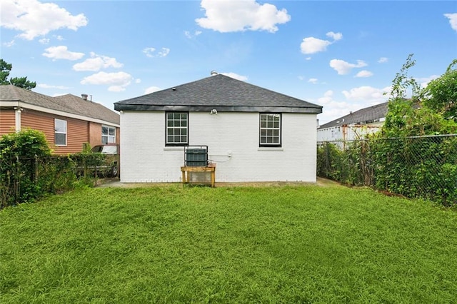 1621 Congress St, New Orleans, LA 70117 - rear view of property with brick siding, a fenced backyard, and roof with shingles