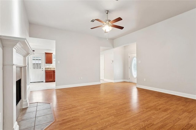 41151 Snowball Cir, Ponchatoula, LA 70454 - unfurnished living room featuring ceiling fan, light wood-style flooring, and a fireplace with flush hearth