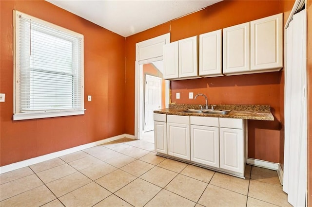 264951 Bruxelles St, New Orleans, LA 70119 - kitchen featuring white cabinets, light tile patterned floors, and dark countertops
