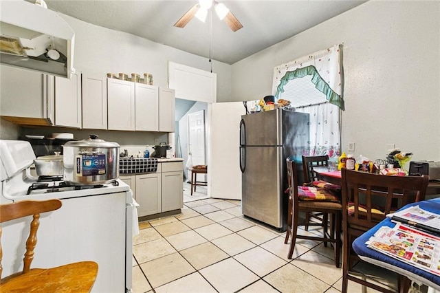 264951 Bruxelles St, New Orleans, LA 70119 - kitchen featuring freestanding refrigerator, white gas range, a ceiling fan, light tile patterned flooring, and exhaust hood