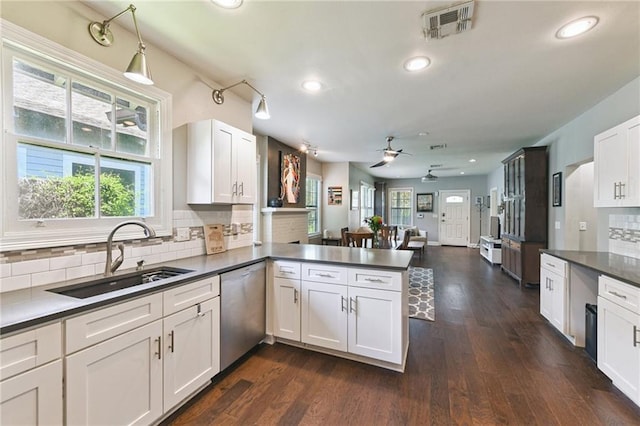 4472 Demontluzin St, New Orleans, LA 70122 - kitchen with dishwasher, a peninsula, a ceiling fan, decorative backsplash, and white cabinets