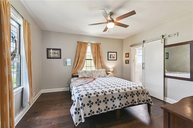 4472 Demontluzin St, New Orleans, LA 70122 - bedroom with dark wood finished floors, a barn door, and ceiling fan