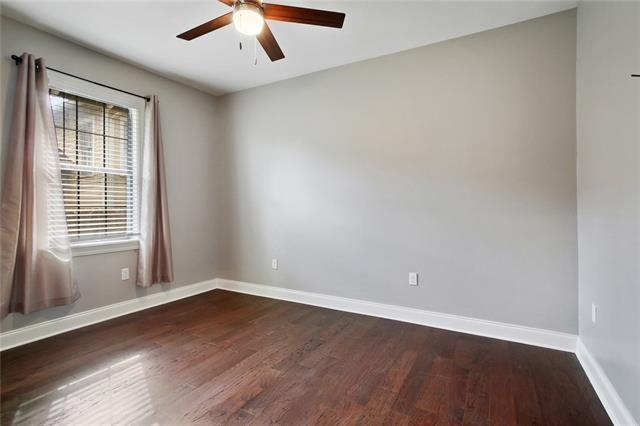4472 Demontluzin St, New Orleans, LA 70122 - empty room with dark wood-style floors and ceiling fan