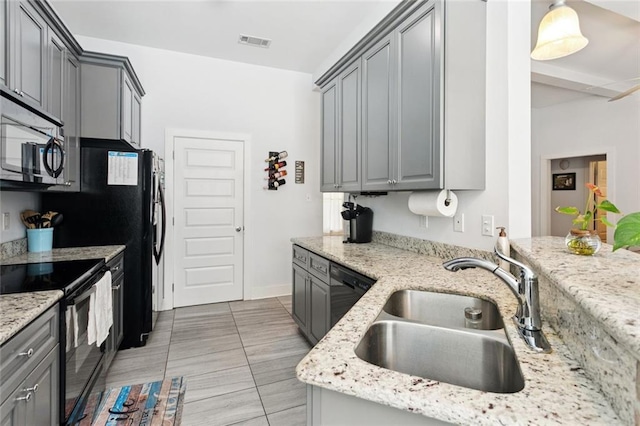 1383 Cherry St, Slidell, LA 70460 - kitchen featuring black appliances, gray cabinets, light stone counters, and decorative light fixtures