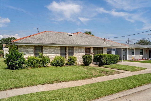 15 Tulip Dr, Gretna, LA 70053 - ranch-style house with a front yard, brick siding, driveway, and roof with shingles