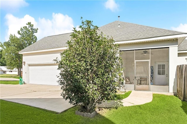 24 Minter Dr, Mandeville, LA 70471 - rear view of house featuring a sunroom, roof with shingles, driveway, a yard, and a ceiling fan