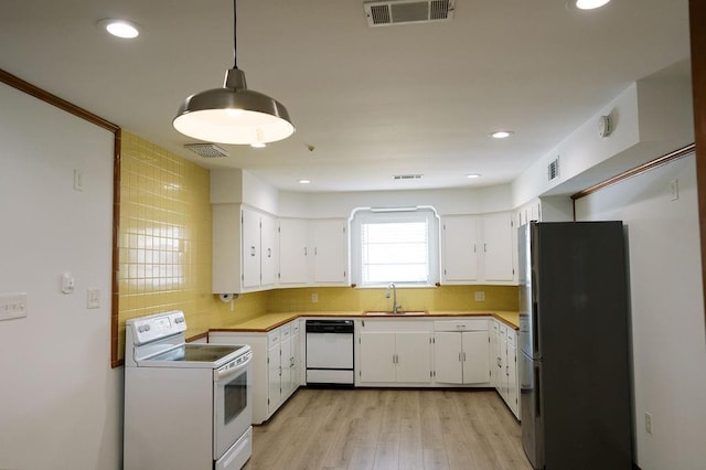 6 Gelbke Dr, Gretna, LA 70053 - kitchen featuring white appliances, backsplash, white cabinets, light wood finished floors, and recessed lighting