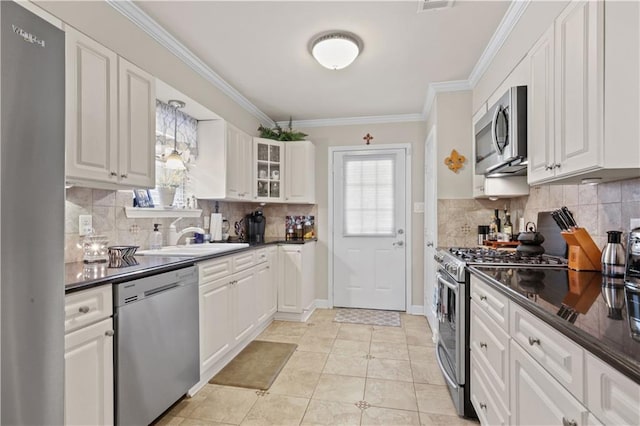 4412 Clearlake Dr, Metairie, LA 70006 - kitchen featuring stainless steel appliances, healthy amount of natural light, dark countertops, and crown molding